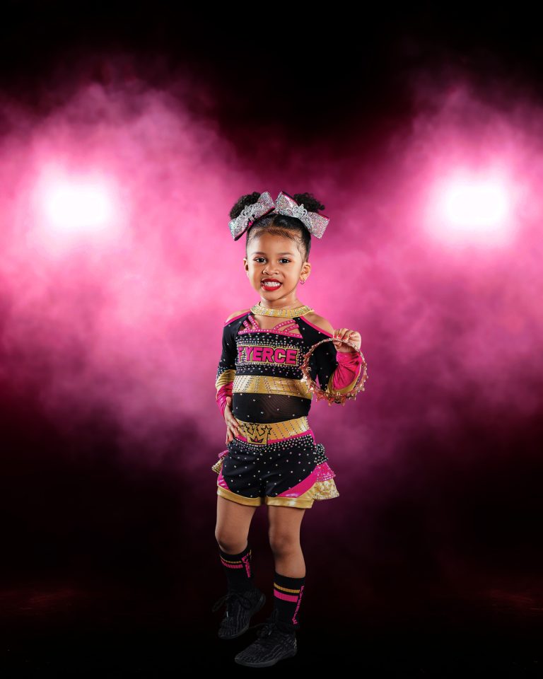 All star cheer posing with dramatic smoke and gel lighting.