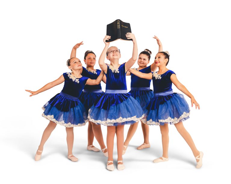 Group dance photo of girls posing around a Bible on their dance studio photo day.