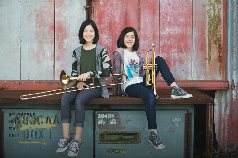 Sibling band students posing outdoors with their instruments in Lakeland, Florida