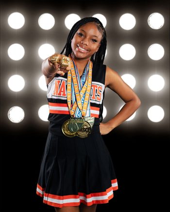 lakeland, florida cheerleader wearing medals and championship rings in front of a promod digital backdrop