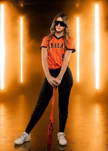high school softball player posing with her bat on an led light digital backdrop