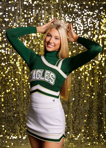 lakeland, florida cheerleader in front of the bc visuals shimmer wall, she's wearing a tiara with her cheer uniform