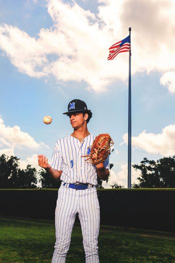 central florida high school baseball player on the field with ball, glove and american flagpole in the background