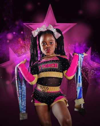 Cute cheerleader posing with her medals on all star cheer gym photo day.