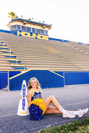 senior cheerleader on auburndale football field using environmental setting and natural light