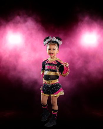 All star cheer posing with dramatic smoke and gel lighting.