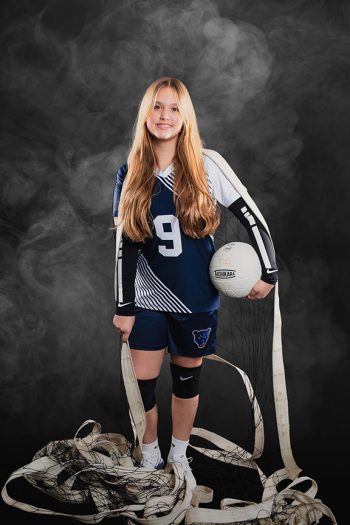 female volleyball player posing the the net and ball on a digital background