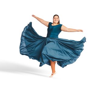 Dancer portrait in flowy costume taken on a simple white backdrop