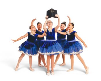 Group dance photo of girls posing around a Bible on their dance studio photo day.