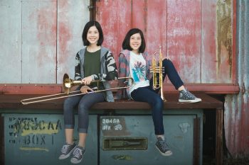 Sibling band students posing outdoors with their instruments in Lakeland, Florida