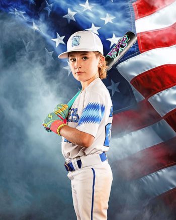 Photo of a young baseball player for a lakeland, florida travel ball team taken on media day in front of an american flag digital backdrop