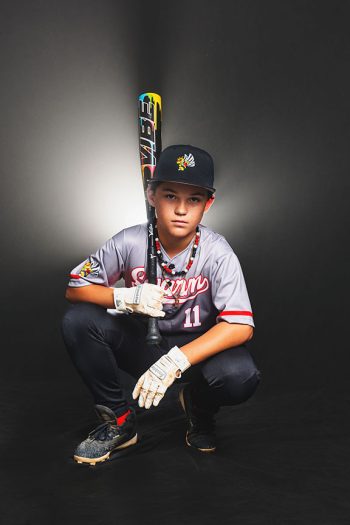 Young baseball player holding a bat in the bc visuals bartow florida studio with dramatic smoke and lights