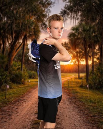 cross country runner holding shoes for school sports photo day in lakeland, florida