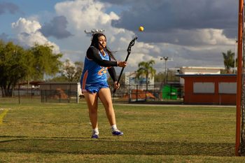 high school lacrosse action shot throwing ball into goal