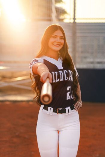 lakeland, florida softball player holding bat at sunset on home field