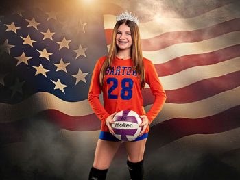 bartow, florida volleyball player holding ball and wearing a tiara in front of a digital american flag backdrop