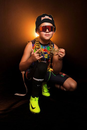young flag football player wearing lots of swag in front of dramatic light and smoke background in bartow, florida studio