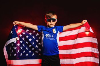 young soccer player holing an american flag with bc visual signature lighting and smoke
